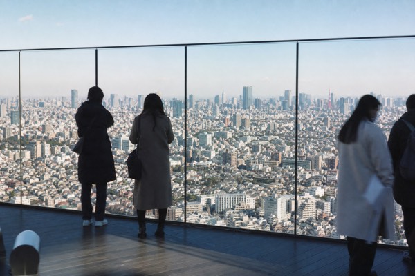 Visitors on the rooftop deck 229 meters above Shibuya in daylight, city grid stretching to the horizon